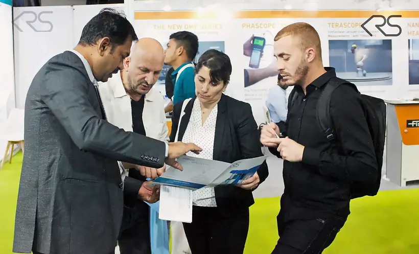 KRS representative discussing machine documentation with visitors at ECS 2025