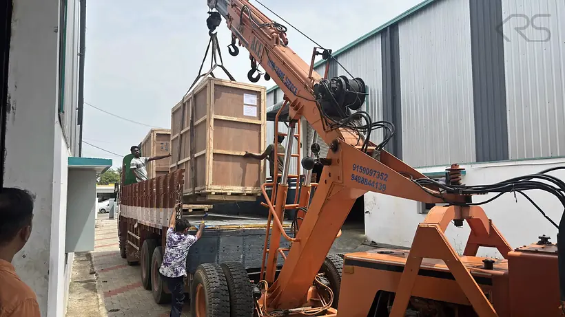 Crated KRS machinery being loaded onto a truck by crane