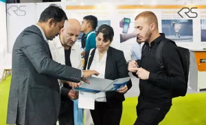 KRS representative discussing machine documentation with visitors at ECS 2025
