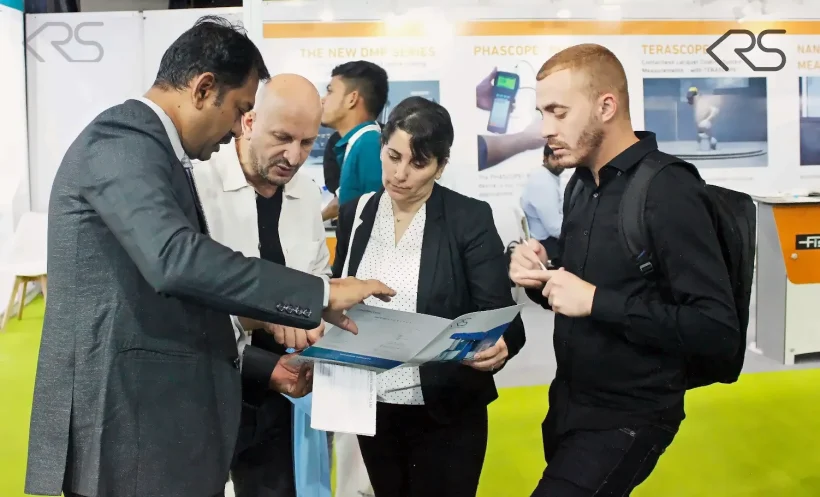 KRS representative discussing machine documentation with visitors at ECS 2025