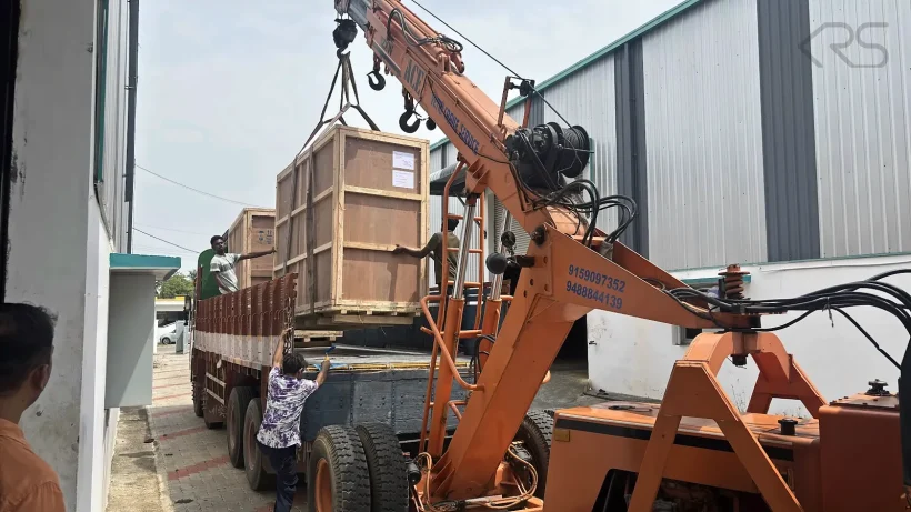 Crated KRS machinery being loaded onto a truck by crane